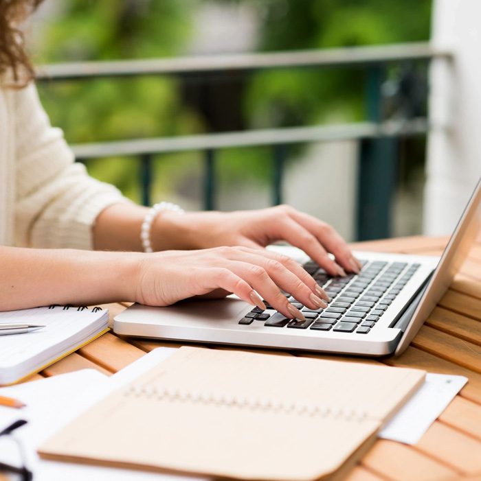 A person typing on a laptop computer.